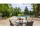 Backyard pool surrounded by lush greenery, featuring a dining set and decorative waterfall feature at 1089 Laurelwood, Carmel, IN 46032