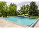 Backyard pool with water feature surrounded by lush green landscaping, creating a private oasis at 1089 Laurelwood, Carmel, IN 46032