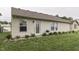 Backyard featuring a manicured lawn, a back door, trimmed shrubbery, and a BBQ grill at 11117 Waterfield Pl, Indianapolis, IN 46235