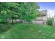 Well-maintained backyard features a mature tree, verdant grass, and a classic white picket fence at 11222 Boston Way, Fishers, IN 46038
