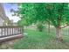 Lush backyard featuring a wood deck, vibrant greenery, mature trees, and a charming picket fence at 11222 Boston Way, Fishers, IN 46038