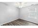 A well lit gray bedroom with wood flooring and a modern ceiling fan at 11222 Boston Way, Fishers, IN 46038
