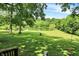 Picturesque backyard featuring lush lawn, mature trees, pond with platform and slide, and rope swings at 1155 Cope Rd, Martinsville, IN 46151