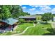 Expansive backyard featuring a large lawn, covered outdoor space, and mature trees at 1155 Cope Rd, Martinsville, IN 46151