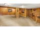 Basement with wood paneled walls, carpet, and a bar area with seating, ideal for entertaining guests at 1155 Cope Rd, Martinsville, IN 46151