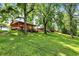 Outdoor entertaining area with wood features on expansive green lawn with mature trees and a slide leading to the lawn at 1155 Cope Rd, Martinsville, IN 46151
