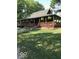 Home's inviting exterior, highlighted by a wooden porch, mature landscaping, and hanging plants at 1155 Cope Rd, Martinsville, IN 46151