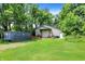 Exterior building featuring a large roll-up door, side door, and surrounded by green grass and trees at 1155 Cope Rd, Martinsville, IN 46151