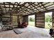 Open garage with wood trusses, concrete floor, and open doorway to the greenery outside at 1155 Cope Rd, Martinsville, IN 46151