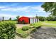 Exterior view of outbuilding featuring concrete and grass driveway, mature trees, and sunny sky at 1155 Cope Rd, Martinsville, IN 46151