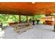Spacious outdoor covered patio featuring a picnic table, seating, bar, and lush surroundings, perfect for entertaining at 1155 Cope Rd, Martinsville, IN 46151