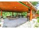 Expansive outdoor covered patio featuring a picnic table, seating, bar area, and lush greenery at 1155 Cope Rd, Martinsville, IN 46151