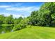 Relaxing pond view with dock, diving platform, and lush green trees surrounding the grassy area at 1155 Cope Rd, Martinsville, IN 46151