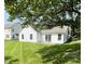 Exterior view of home with well-manicured lawn, patio, and mature tree shading the yard at 1173 Carlton Ct, Greenwood, IN 46143
