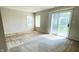 Bright, carpeted living area with large windows and a sliding glass door to the outside at 1173 Carlton Ct, Greenwood, IN 46143