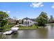 Aerial view of a lakefront property with a stunning house, swimming pool, and private dock at 12208 Island Dr, Indianapolis, IN 46256