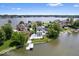 Aerial view of a luxurious home with a pool, dock, and manicured lawn on the lake at 12208 Island Dr, Indianapolis, IN 46256