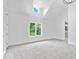 Bedroom featuring carpet, white walls, and a window overlooking the trees and river at 12208 Island Dr, Indianapolis, IN 46256