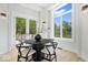 Bright dining area with a black round table, white chairs, and scenic backyard views at 12208 Island Dr, Indianapolis, IN 46256