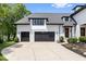 A pristine home exterior with a three-car garage and lush landscaping at 12208 Island Dr, Indianapolis, IN 46256