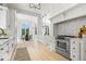 Open kitchen and dining area with white cabinets, stainless steel appliances, and herringbone backsplash at 12208 Island Dr, Indianapolis, IN 46256
