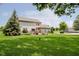 Expansive backyard with mature trees, green lawn, and a deck with a pergola, perfect for outdoor living at 12251 E 196Th St, Noblesville, IN 46060
