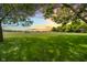 Expansive green backyard featuring a small shed, mature trees, and a serene country sunset at 12251 E 196Th St, Noblesville, IN 46060