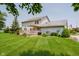 Home's backyard with a spacious deck, lush lawn, mature trees, and American flag at 12251 E 196Th St, Noblesville, IN 46060