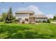 Home's large backyard featuring a lush lawn, mature trees, and a spacious deck with a pergola at 12251 E 196Th St, Noblesville, IN 46060