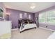 This bedroom has purple walls, a window providing natural light, and carpeted floors at 12251 E 196Th St, Noblesville, IN 46060