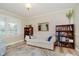 Bright living room with hardwood floors, white sofa with blue pillows, and natural light from a large window at 12251 E 196Th St, Noblesville, IN 46060