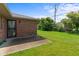 A brick home with a large grassy backyard under a bright, blue sky at 1309 Wyoming Way, Anderson, IN 46013