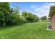 Expansive backyard with privacy trees, chain link fence, and lush green lawn at 1309 Wyoming Way, Anderson, IN 46013
