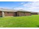 Expansive backyard view of a well-maintained lawn featuring mature grass and brick architecture of this inviting residential property at 1309 Wyoming Way, Anderson, IN 46013