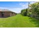 Large grassy backyard with mature landscaping and views of the rear of other brick homes at 1309 Wyoming Way, Anderson, IN 46013