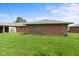 A well-maintained backyard with a lush green lawn complements the charming brick architecture of this inviting residential property at 1309 Wyoming Way, Anderson, IN 46013