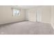 A spacious bedroom with neutral carpeting, two doors and a window with a pleasant view at 1309 Wyoming Way, Anderson, IN 46013