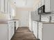 Well-lit kitchen featuring white cabinets, wood-look floors, and essential appliances at 1309 Wyoming Way, Anderson, IN 46013
