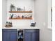 Chic bar area features custom floating shelves, beverage cooler, and modern navy blue cabinetry at 14453 Glapthorn Rd, Fishers, IN 46037