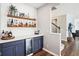 Stylish bar area with floating shelves, a beverage cooler, and blue cabinets that enhance the contemporary design at 14453 Glapthorn Rd, Fishers, IN 46037