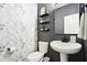 Chic powder room featuring patterned wallpaper, pedestal sink, black fixtures, and modern decor at 14453 Glapthorn Rd, Fishers, IN 46037