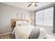 Bright bedroom featuring a ceiling fan, natural light from the window, and neutral decor with wicker accents at 14453 Glapthorn Rd, Fishers, IN 46037