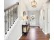 Inviting entryway with wood floors, console table, decorative lighting, and staircase with ornamental iron balusters at 14453 Glapthorn Rd, Fishers, IN 46037