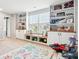 Well-organized playroom featuring built-in shelving, window seating, and a playful dinosaur rug at 14453 Glapthorn Rd, Fishers, IN 46037