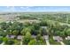 Expansive aerial of neighborhood showcasing tree-lined streets, greenery, nearby school and soccer field at 1482 Waterford Dr, Zionsville, IN 46077