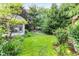 View of backyard with lush green lawn, colorful flowerbeds and a stone patio at 1482 Waterford Dr, Zionsville, IN 46077