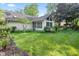 Spacious backyard with manicured lawn, bordered by mature trees and flower beds, showcasing the home's exterior at 1482 Waterford Dr, Zionsville, IN 46077