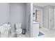 Accessible bathroom with a toilet, sink, handrails, and tiled floor at 1482 Waterford Dr, Zionsville, IN 46077
