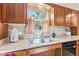 Close up of a sink, wooden cabinets and window with curtains at 1482 Waterford Dr, Zionsville, IN 46077