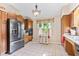 Bright kitchen featuring stainless steel appliances, wood cabinets, and a window with curtains at 1482 Waterford Dr, Zionsville, IN 46077